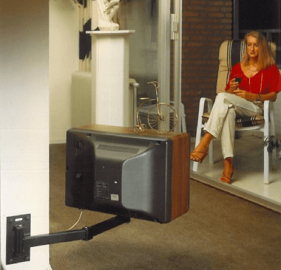 Woman sitting in front of the TV with the first Vogel's TV wall mount | Vogel's 